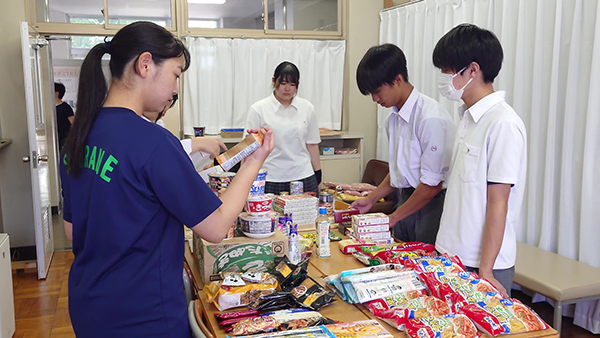 高校でのフードドライブ（スクールフードドライブ）活動の様子。集めた食品を点検している／出典：フードバンク山梨